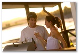 Shaws Bay Holiday Park - East Ballina: Couple having BBQ on the deck in Riverview Cabin