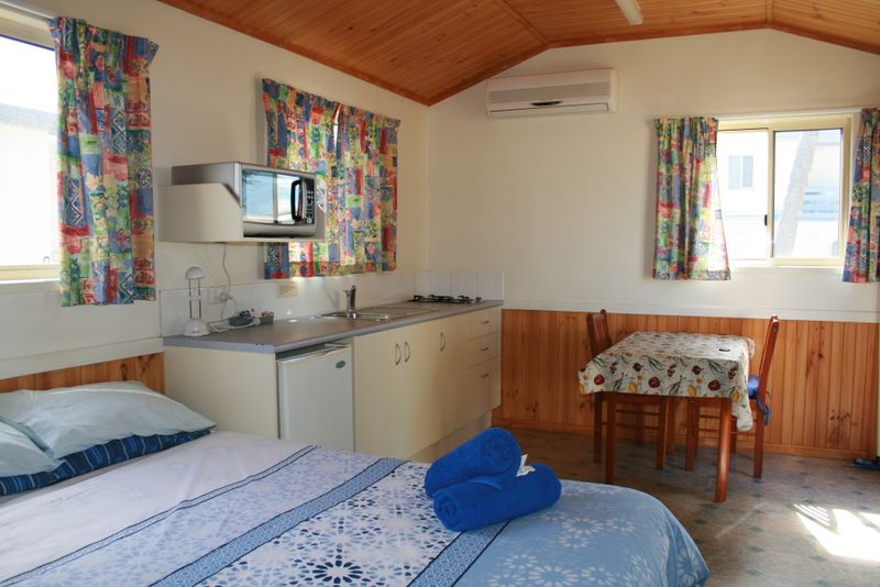 Harbour Lights Caravan Park - Bowen: Interior of cottage showing bedroom, kitchen and dining area.