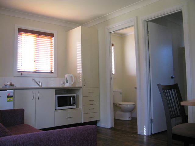 John Oxley Caravan Park - Coonabarabran: Interior of cottage showing modern fully equipped kitchen and dining room.