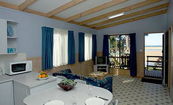Joalah Holiday Park - Durras North: Lounge room in Waterfront and Waterview Deluxe Cabin