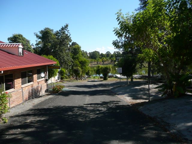 Twin Lakes Village Caravan Park - Gympie: Paved road leading down to office and scenic lake