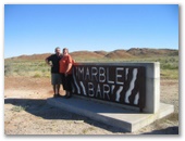 Marble Bar Holiday Park - Marble Bar: Roger and Jeanette at Town Welcome sign.
