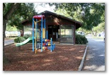 Bellinger River Tourist Park - Repton: Playground for children with camp kitchen in the background.