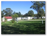 Sydney Getaway Holiday Park - Vineyard: Powered sites for caravans with cabins in the background