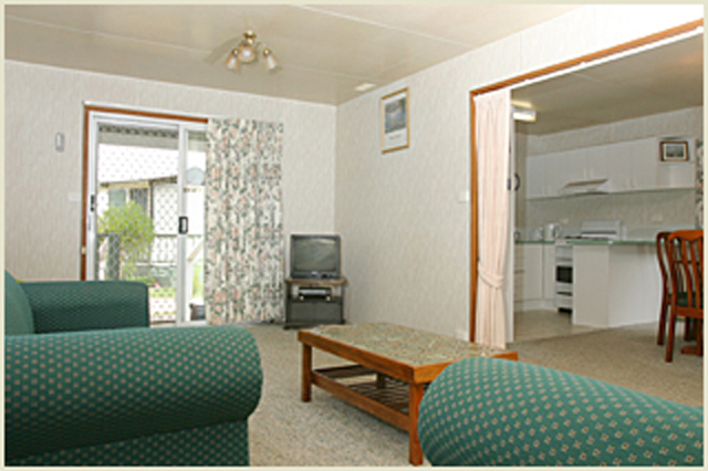 Barlings Beach Tourist Park - Tomakin: Lounge room in Deluxe Cabin