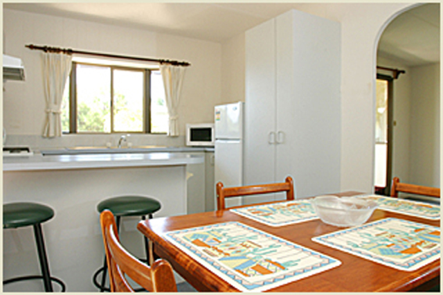 Barlings Beach Tourist Park - Tomakin: Kitchen and Dining Area in Standard Cabin