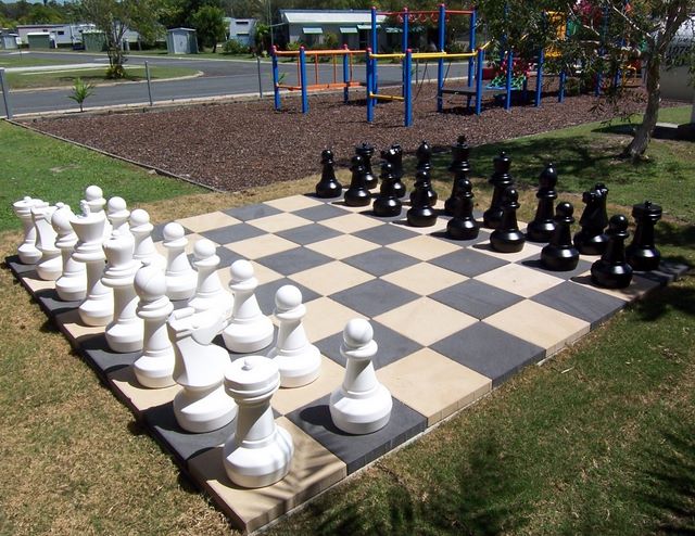 Yamba Waters Holiday Park - Yamba: Chess set with playground for children in the background